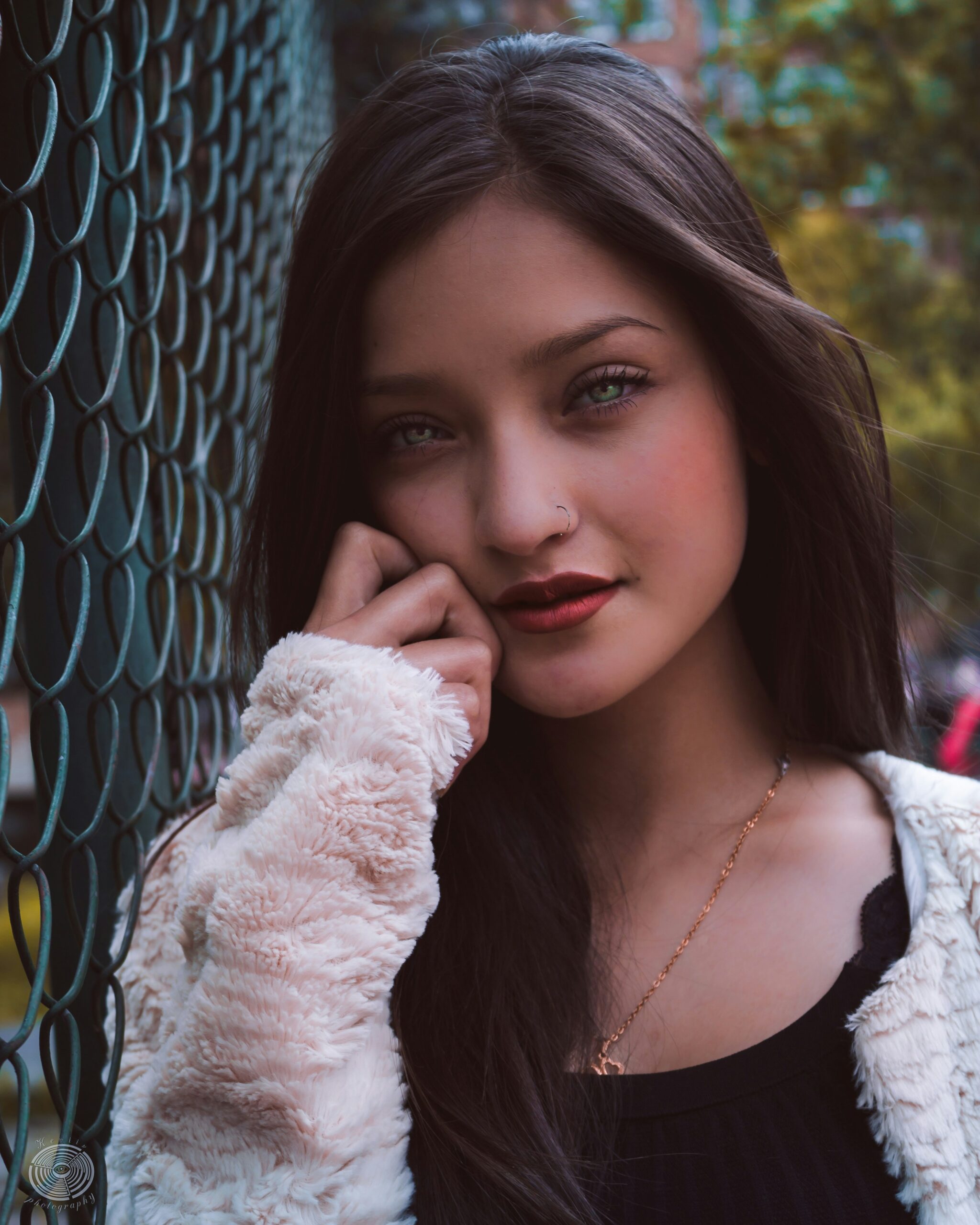 woman leaning on wire fence at daytime